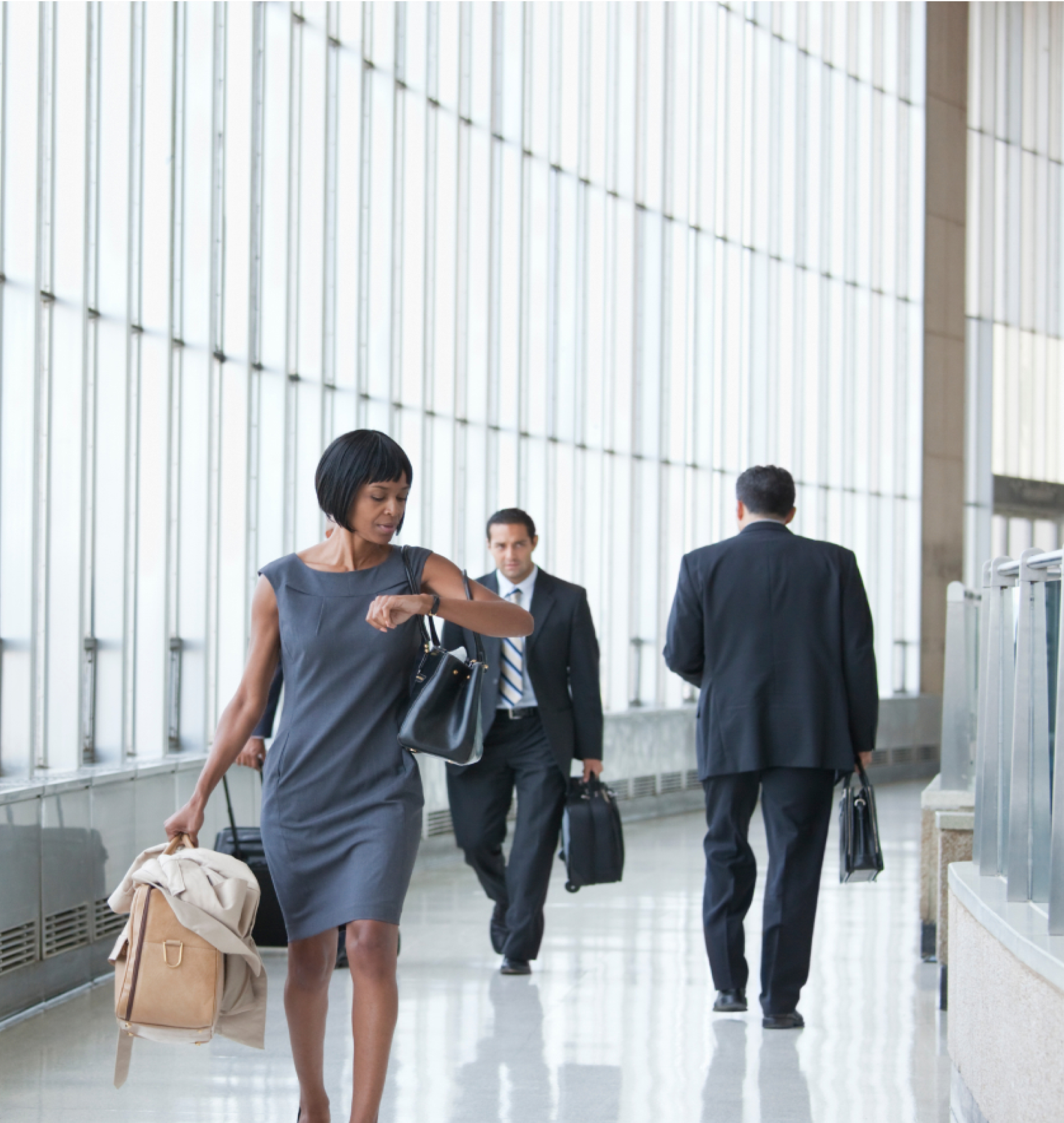 Woman in dress hurriedly walking through a busy office